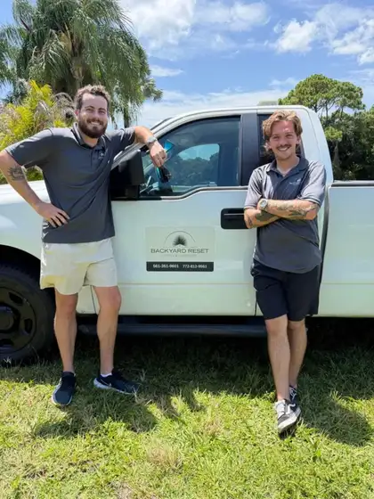 The two-person My Backyard Reset crew beside their work truck